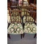 A set of seven Georgian style mahogany dining chairs with green upholstered seats comprising one