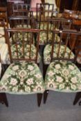 A set of seven Georgian style mahogany dining chairs with green upholstered seats comprising one