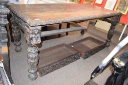 Victorian gothic oak writing table of rectangular form with heavy carved legs, two frieze drawers