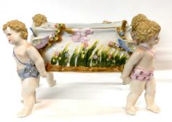 A continental porcelain jardiniere, the four corners supported by winged cherubs, 34cm long