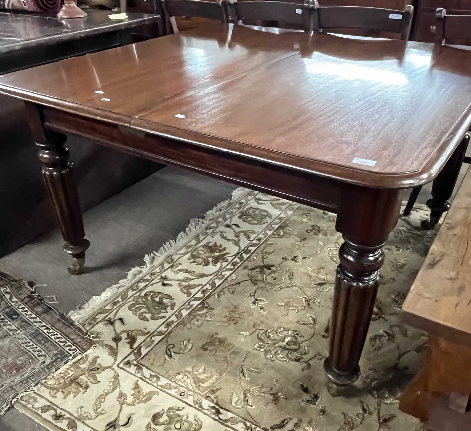 A large Victorian mahogany extending dining table on turned fluted legs with pull out action and two - Image 2 of 4