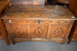 An 18th Century oak coffer with three panelled front, decorated with a geometric inlaid design,