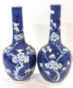 A large pair of 19th Century Chinese porcelain bottle vases, the blue ground with prunus decoration,