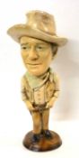 A ceramic sculpture of John Wayne on circular base, 48cm high