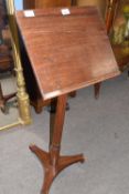 A late 19th Century mahogany adjustable music stand of typical form set on a three footed base,