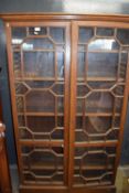 A Victorian oak bookcase cabinet with two glazed doors and adjustable interior shelves, 167cm