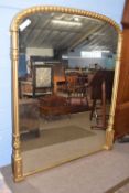 A large 19th Century gilt over mantel mirror of arched form, 157 x 125 cm