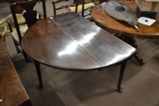 A Georgian mahogany drop leaf dining table raised on tapering legs with pad feet, 135cm wide when