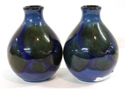 A small pair of Poole vases of baluster shape, decorated in Moorcroft fashion with green design on