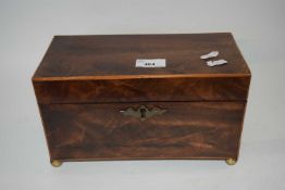 A small 19th Century mahogany tea caddy of hinged rectangular form set on brass ball feet, the