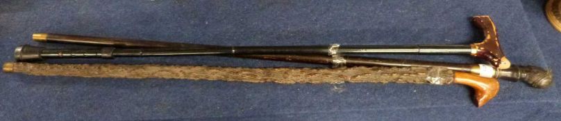 A mixed lot of walking sticks to include an example with a bronzed metal finial formed as a head