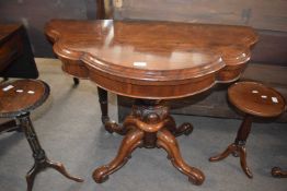 A Victorian rosewood tea table with shaped folding top over a bulbous column and four outswept legs,