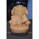 A Georgian style walnut framed wing back armchair with feather filled cushions