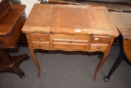 Small continental walnut dressing table with lift up central mirror, two covered side sections and