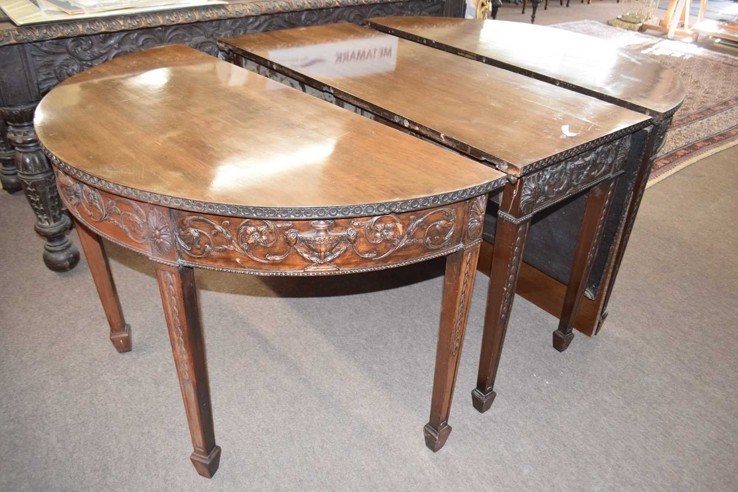 An Adams style mahogany sectional dining table formed of two ends, a central drop leaf section and a