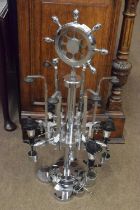 A circular chrome finish revolving bar optic with ships wheel finial in the Art Deco style, 85cm
