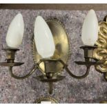 A pair of 20th Century brass three branch wall lights with oval panelled backs, 24cm high