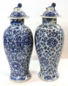 Pair of Chinese porcelain vases and covers with lion finials with blue and white scrolling lotus