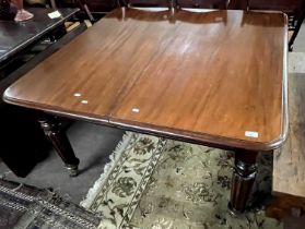 A large Victorian mahogany extending dining table on turned fluted legs with pull out action and two