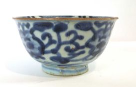 A Chinese porcelain bowl decorated in blue and white with a Ming style design below a brown line