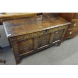 An 18th Century oak coffer with three panelled front raised on style feet, 125cm wide