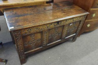 An 18th Century oak coffer with three panelled front raised on style feet, 125cm wide