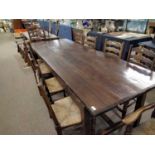 A large oak refectory dining table with H formed stretcher together with a set of ten rush seat