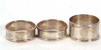 A boxed pair of silver serviette rings, chased and engraved with a band of leaves, hallmarked