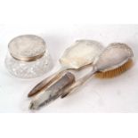 Hallmarked silver three piece mounted dressing table wares including hand mirror, hairbush and glass