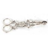 A pair of antique Irish silver sugar tongs, circa 1780 of Rococo scrolled form, the circular hinge