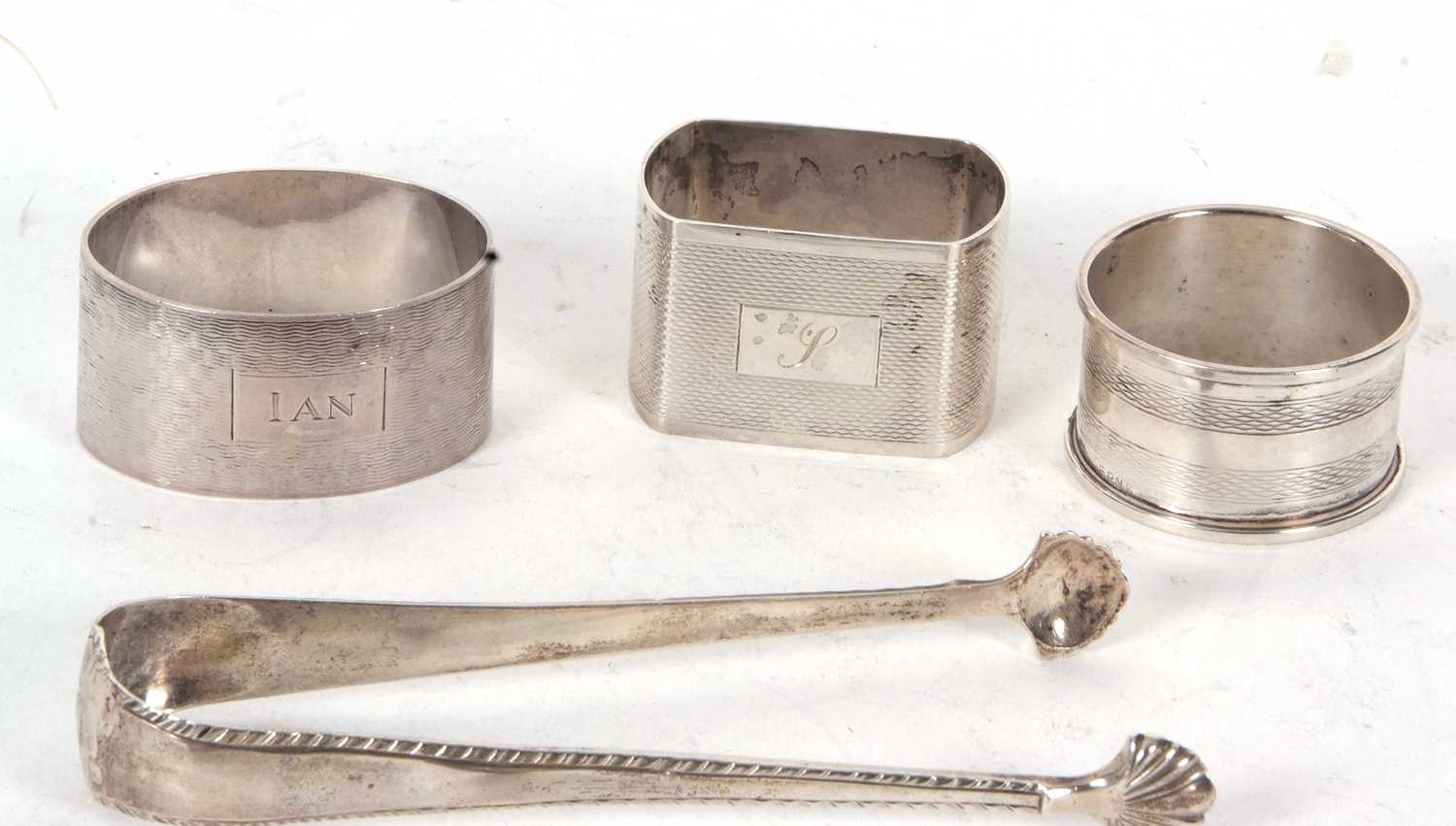 Mixed Lot: Two hallmarked silver serviette rings, a pair of Georgian silver sugar tongs, with - Image 2 of 2