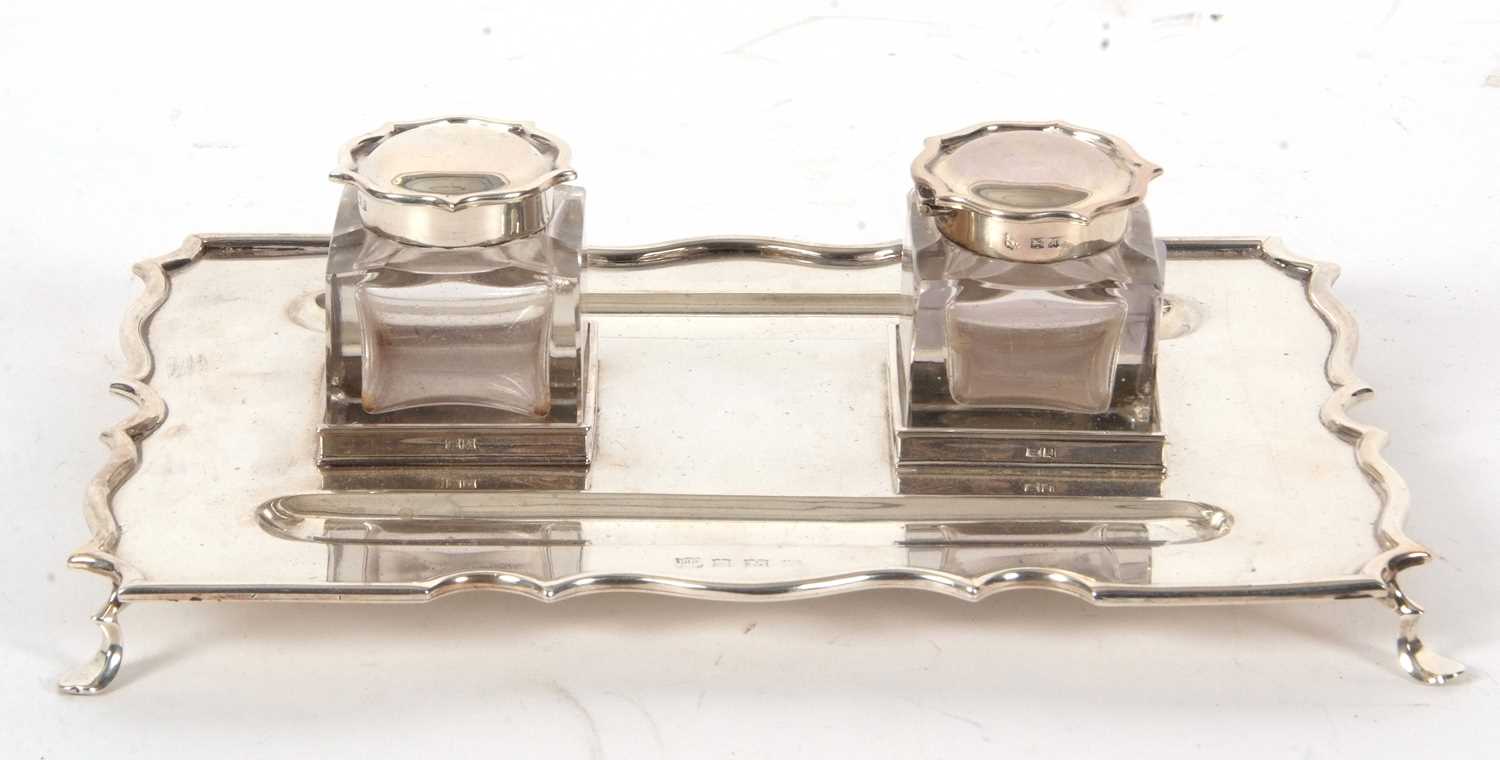 A George VI silver ink stand of rectangular form with a wavey border with two square glass removable