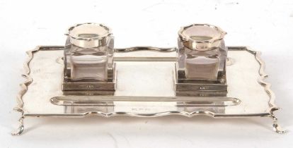 A George VI silver ink stand of rectangular form with a wavey border with two square glass removable