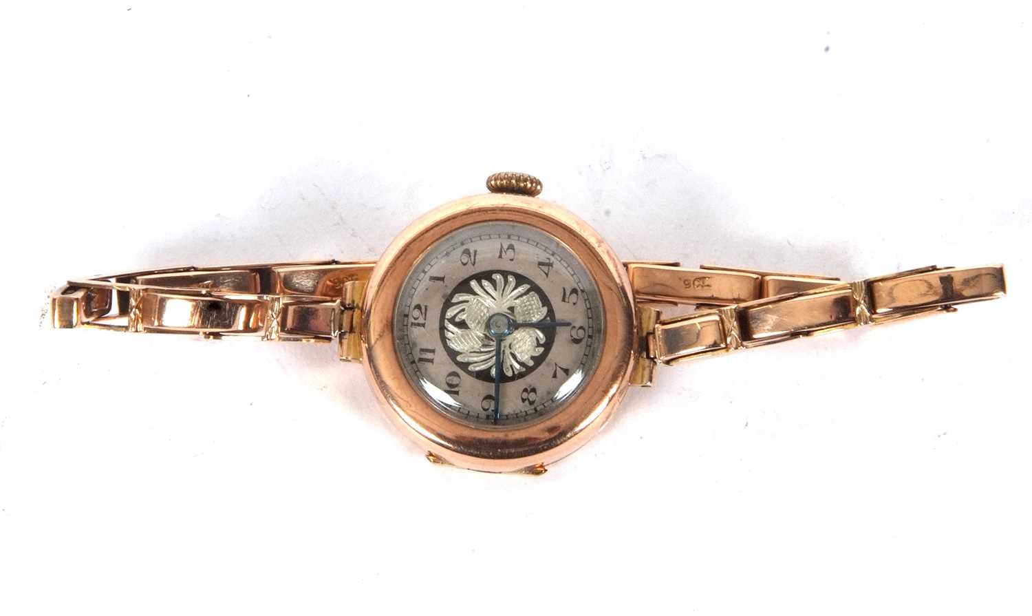 A 9ct gold cased ladies wristwatch on an expanding yellow metal bracelet, the bracelet is stamped