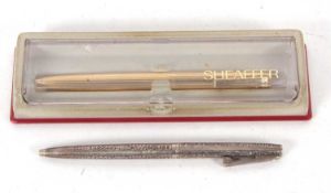 A Sheaffer sterling ball point pen, the barrel engraved with berries and scrolls, the clip a push in