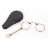 A pair of antique Lorgnette folding glasses, gold plated, in a leather pouch, 12cm long