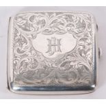 George V silver cigarette case of slightly curved form, chased and engraved with scrolls around an