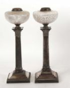 Two silver plated Corinthian column oil lamps each with different cut glass reservoirs (one