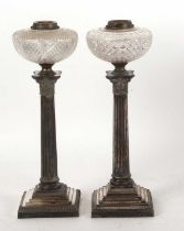 Two silver plated Corinthian column oil lamps each with different cut glass reservoirs (one