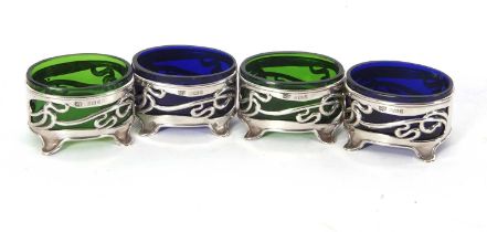 A set of four Art Nouveau silver salts of oval form, pierced with a vine tendril design, supported