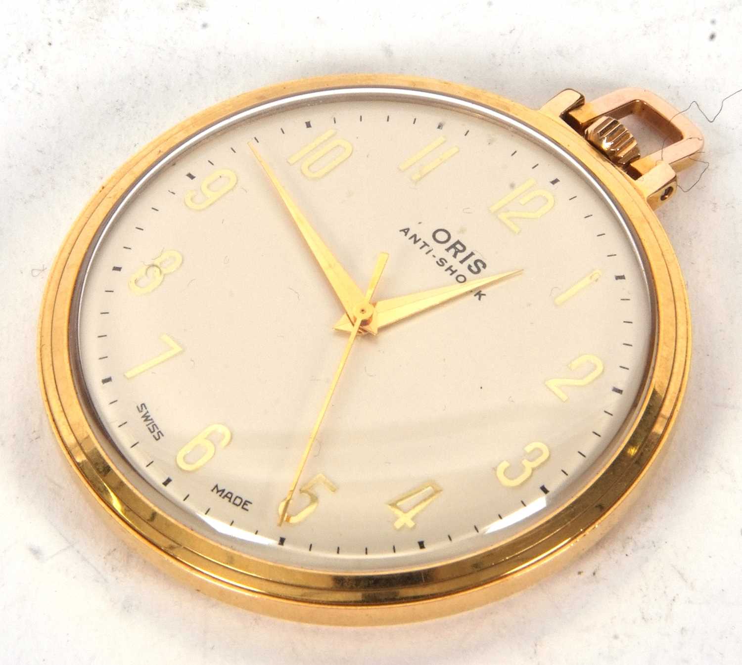 An Oris base metal pocket watch, it has a crown wound movement and a cream dial with gold coloured