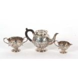 A late Victorian silver three piece bachelor tea service of baluster form, embossed with a floral