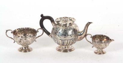 A late Victorian silver three piece bachelor tea service of baluster form, embossed with a floral
