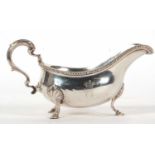 A George III silver large sauce boat of typical form, gadrooned border, leaf-capped scroll handle,