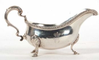 A George III silver large sauce boat of typical form, gadrooned border, leaf-capped scroll handle,