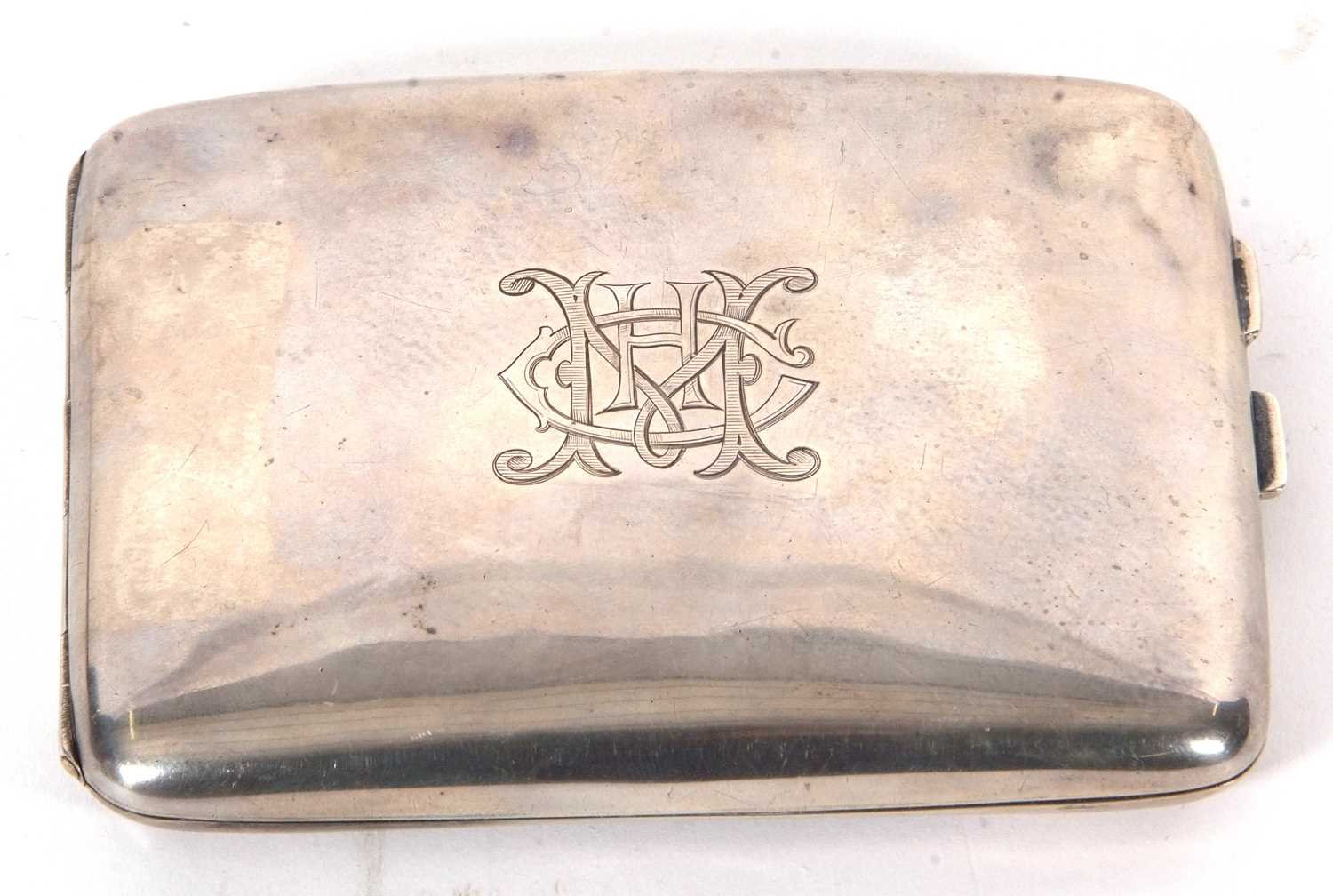 A George V silver cigarette case of slight curved rectangular form, plain polished and engraved