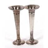 A pair of early 20th Century silver trumpet shaped vases of plain design on loaded bases, hallmarked