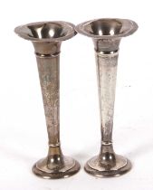 A pair of early 20th Century silver trumpet shaped vases of plain design on loaded bases, hallmarked