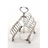 A large Victorian silver toast rack having six shaped divisions, central loop carrying handle,