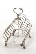 A large Victorian silver toast rack having six shaped divisions, central loop carrying handle,